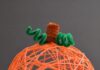 DIY Yarn Pumpkins with Balloons: Step-by-Step Guide Orange yarn pumpkin on a dark background