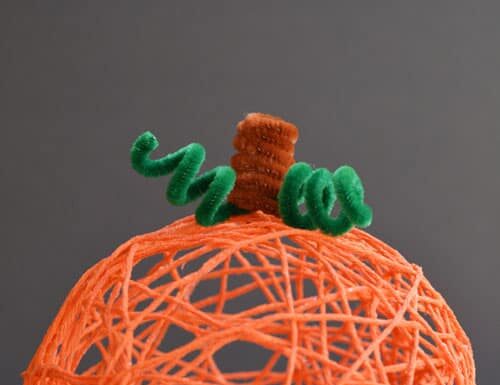 DIY Yarn Pumpkins with Balloons: Step-by-Step Guide Orange yarn pumpkin on a dark background