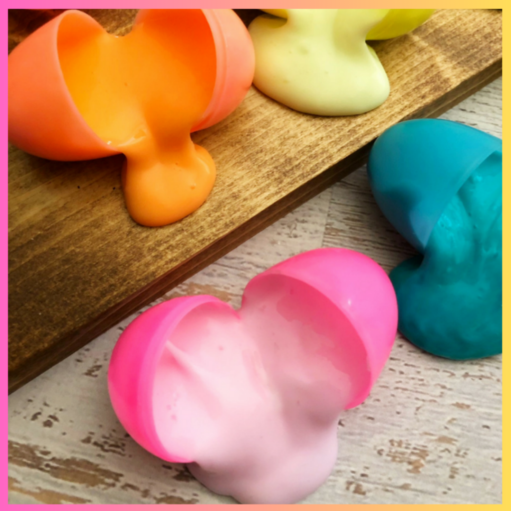 Colorful plastic molds shaped like Easter bunnies and Easter eggs on a wooden surface.