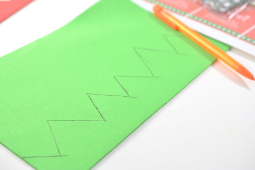 tracing the triangles down to the bottom of the sheet of green craft foam