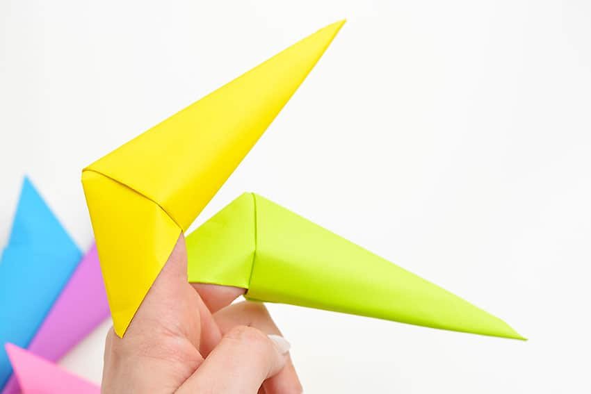 Hand pointing with a colourful folded paper claw