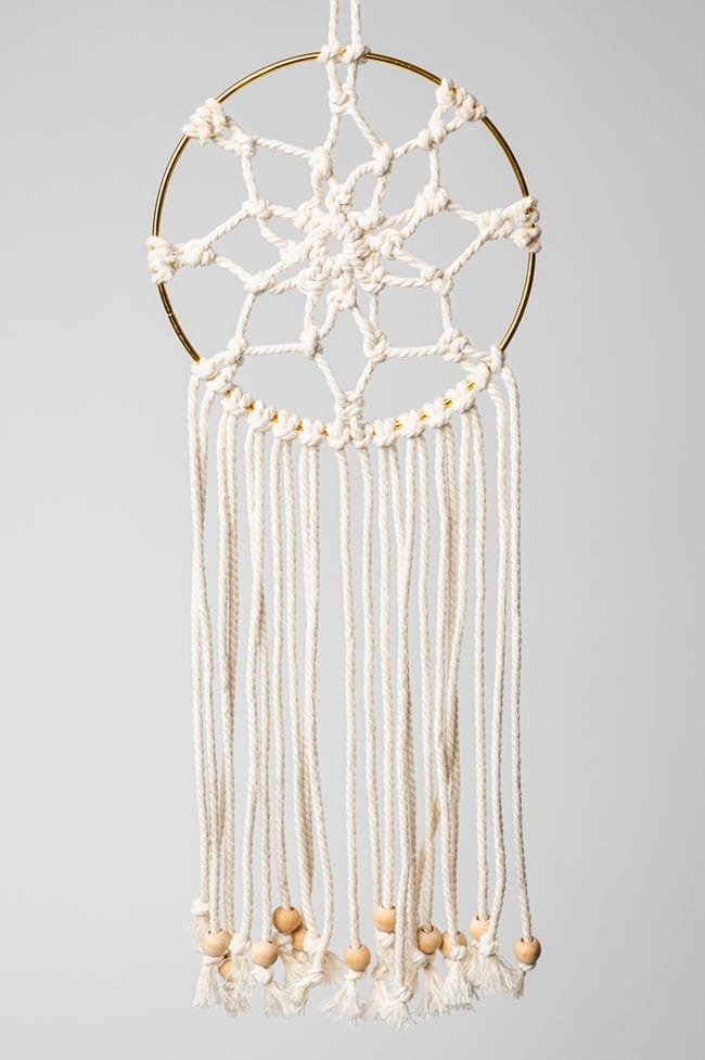 Macrame dream catcher on a gold hoop with wooden beads