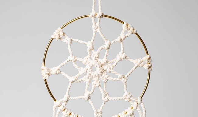 DIY Macrame Dream Catcher (Easy Boho Wall Decor) Macrame dream catcher on a gold hoop with wooden beads