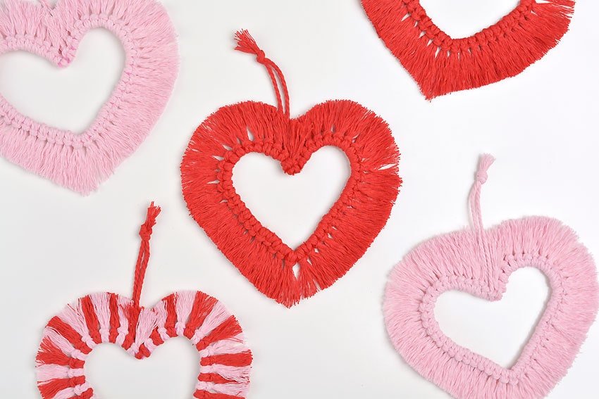 Red Valentine's Day macrame heart with other macrame hearts around it