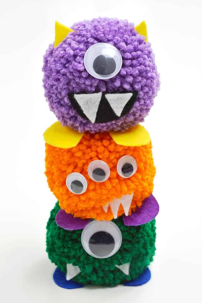 Pom pom monster DIY toys standing on top of one another