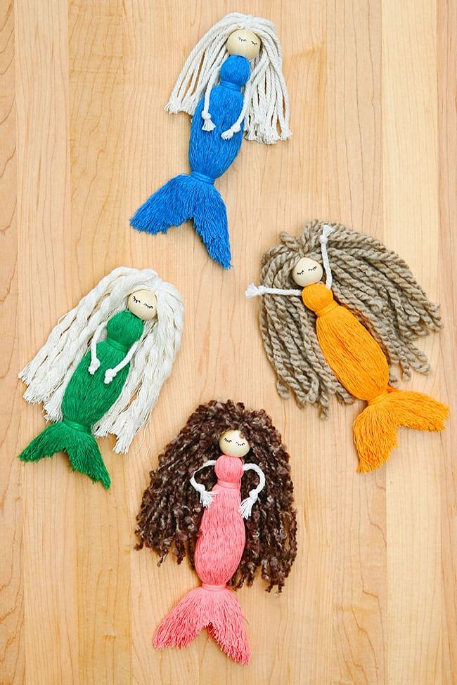 Yarn mermaid dolls on a wooden background