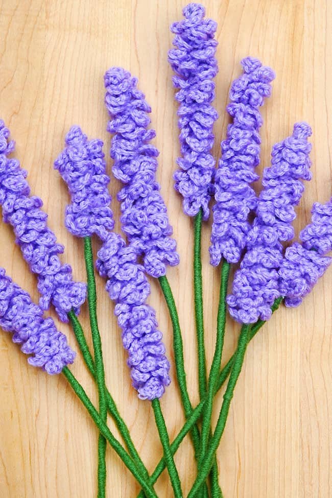 Bundle of crochet lavender flowers on a wood background