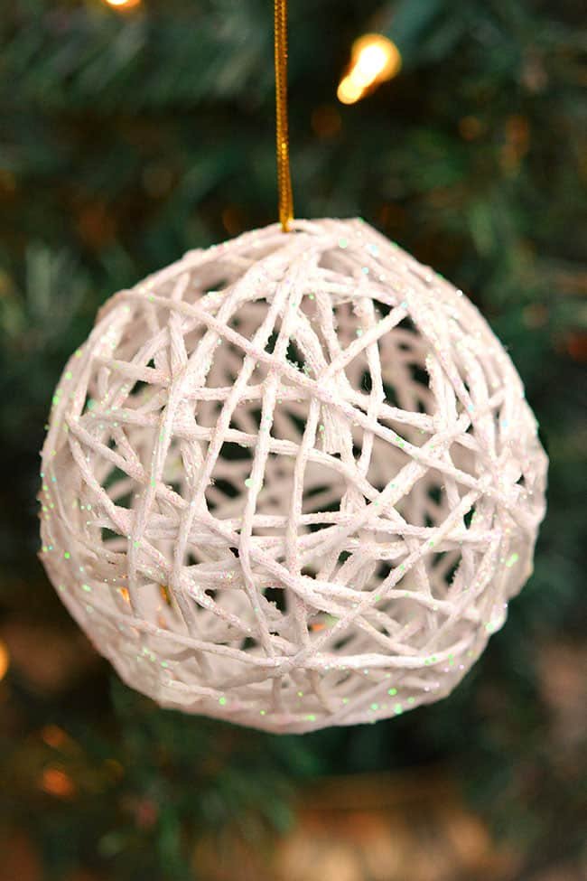 These white glitter ball yarn ornaments using balloons are so PRETTY and they're so much fun to make! They look like snowballs! This is such a fun Christmas craft and a great way to make homemade Christmas ornaments. They look so sparkly and pretty on the Christmas tree! Make them in all your favourite festive colors!