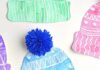 Kids Winter Hat Art Project With DIY Pom Poms This winter hat art project for kids is such a fun winter craft idea! Use the free printable winter hat template to have a fun day of crafting at home or in the classroom! This process art idea lets you experiment with creating texture in watercolor and shows the magic of painting over crayon with watercolour paint! There's even instructions for making a DIY yarn pom pom!