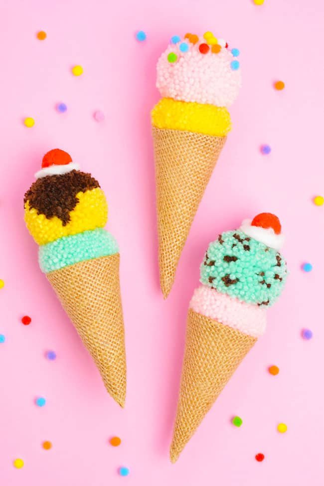 Pom pom ice cream cones decorated with whipped cream, cherries, and sprinkles