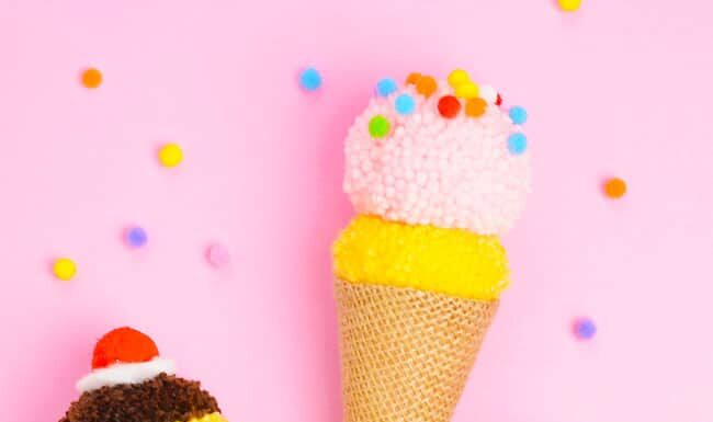 DIY Pom Pom Ice Cream Cones: Fun Summer Craft Pom pom ice cream cones decorated with whipped cream, cherries, and sprinkles