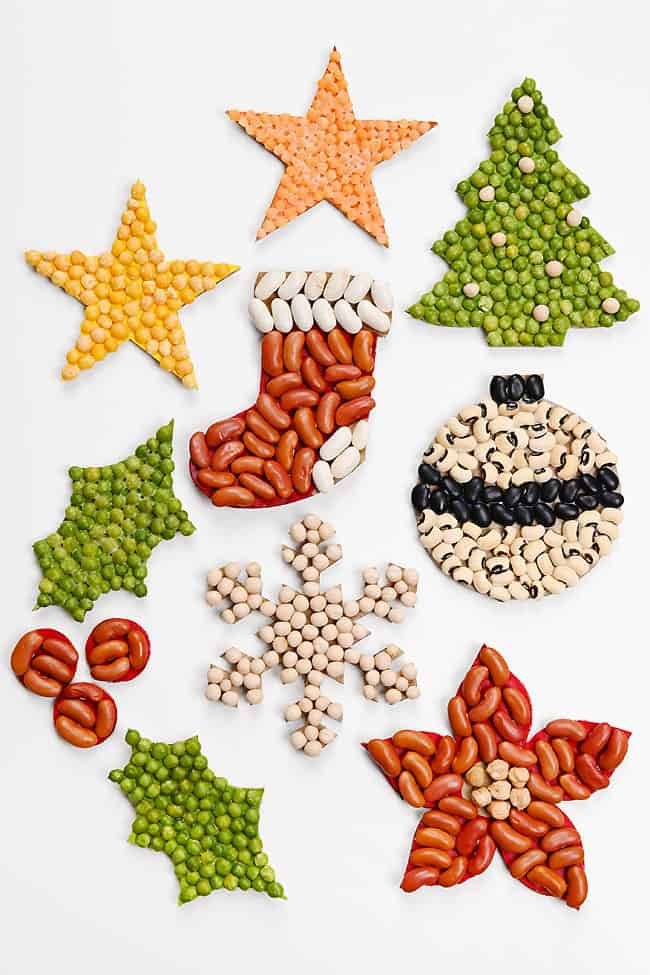 Colourful group of Christmas bean mosaics shaped like stars, holly, stocking, tree, snowflake, poinsettia, and Christmas ornaments