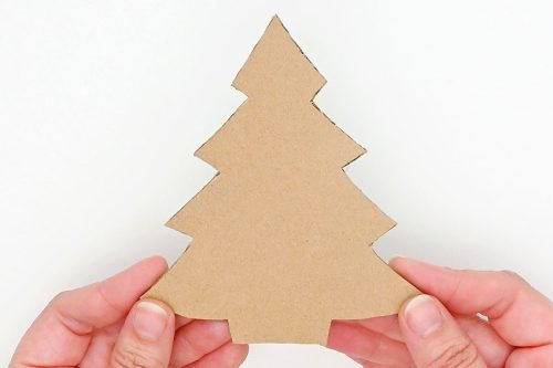 Cardboard tree shape being held by 2 hands