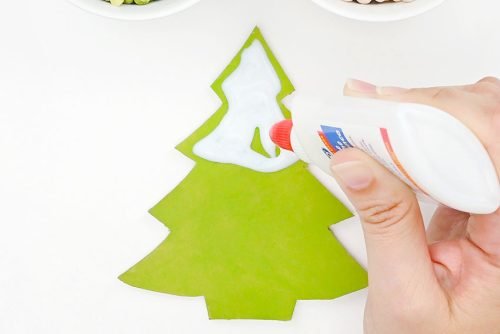 White glue being added to the top of a green tree shape