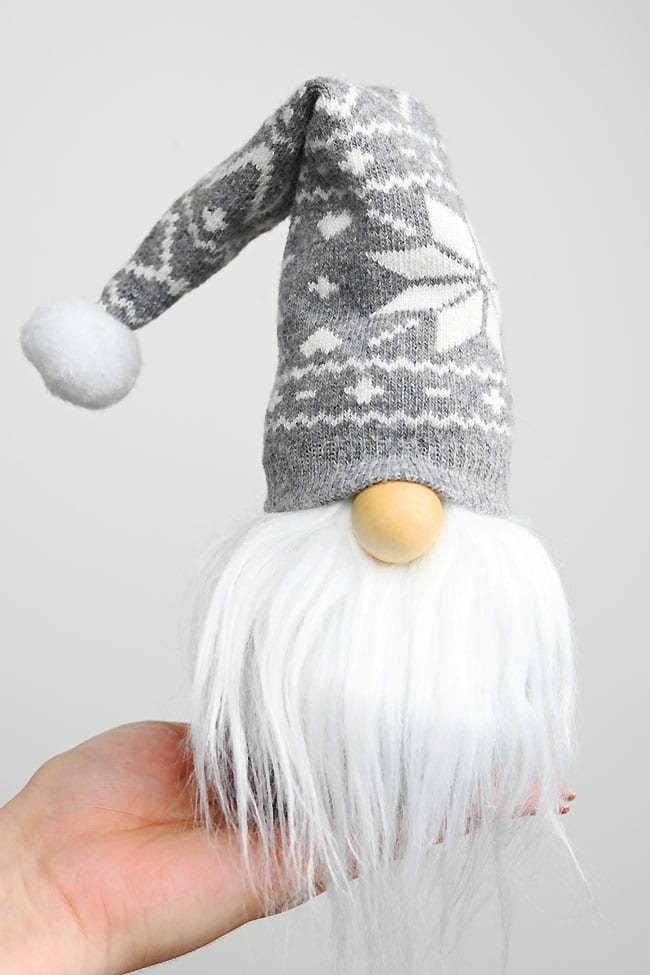 Holding a Christmas gnome with a grey hat