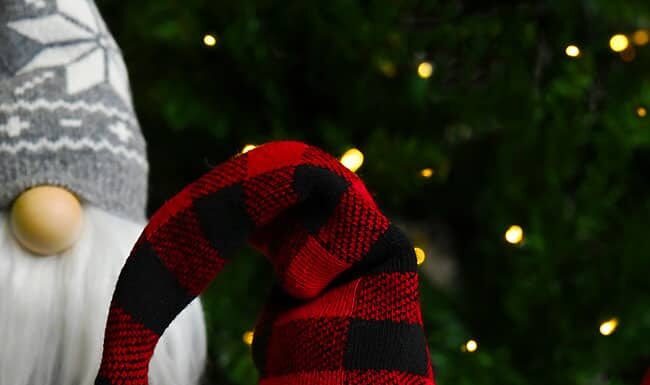 DIY Christmas Gnomes: Festive Handmade Decorations Christmas gnome with red plaid hat in front of gnome with grey snowflake hat