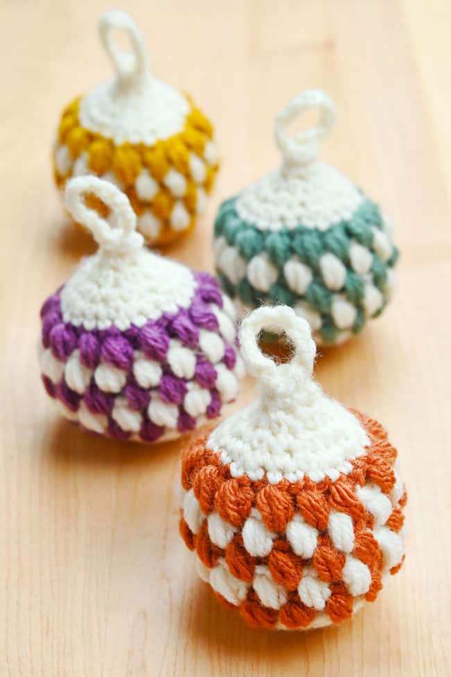 Crochet Christmas baubles on a wood background