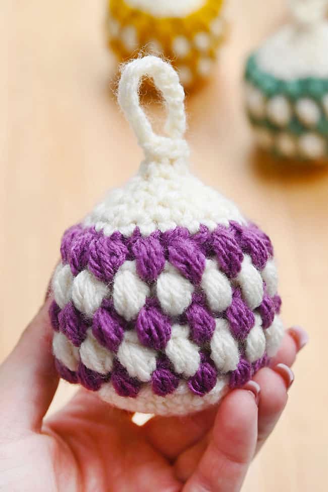 Holding a purple patterned crochet ornament