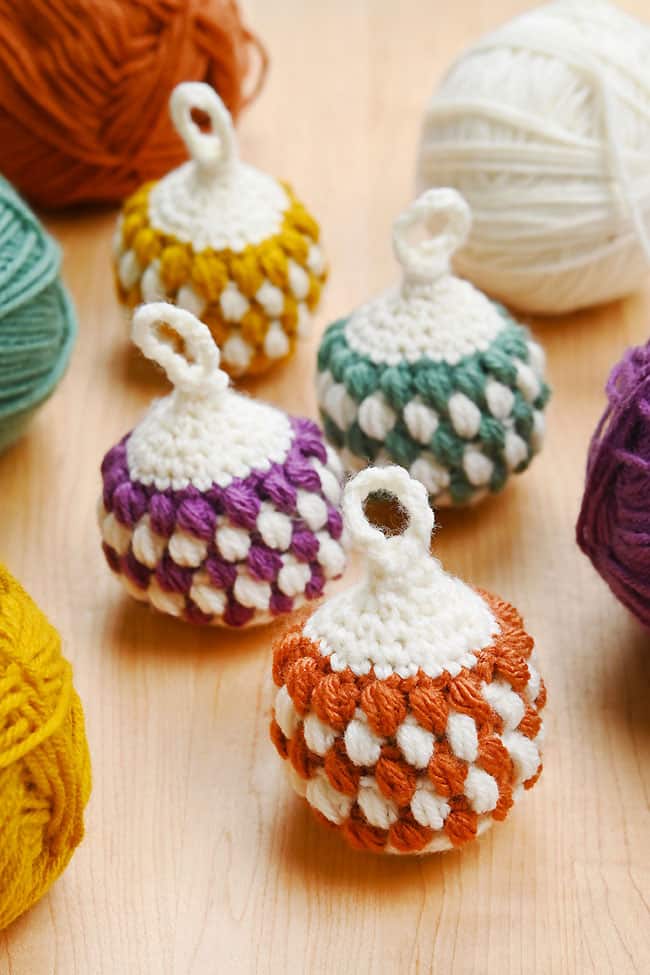 Crocheted Christmas ornaments sitting with yarn used to make them
