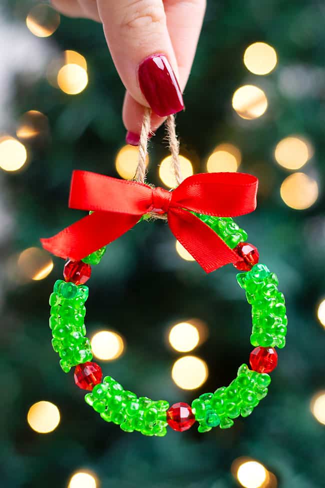 Beaded Christmas wreath ornament in front of a Christmas tree