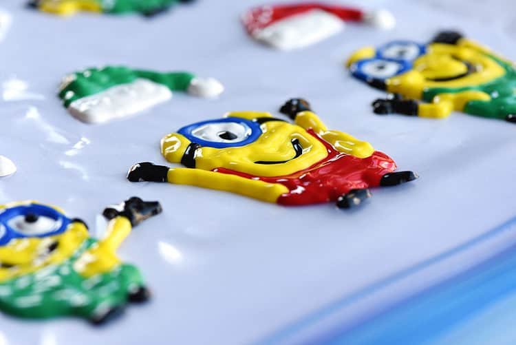 These holiday Minion window clings using Tulip slick paint are SO EASY and they look so cute! This is such a fun Christmas craft to do with the kids and it's seriously one of my all time favourite crafts!