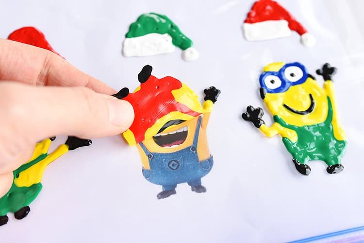 These holiday Minion window clings using Tulip slick paint are SO EASY and they look so cute! This is such a fun Christmas craft to do with the kids and it's seriously one of my all time favourite crafts!