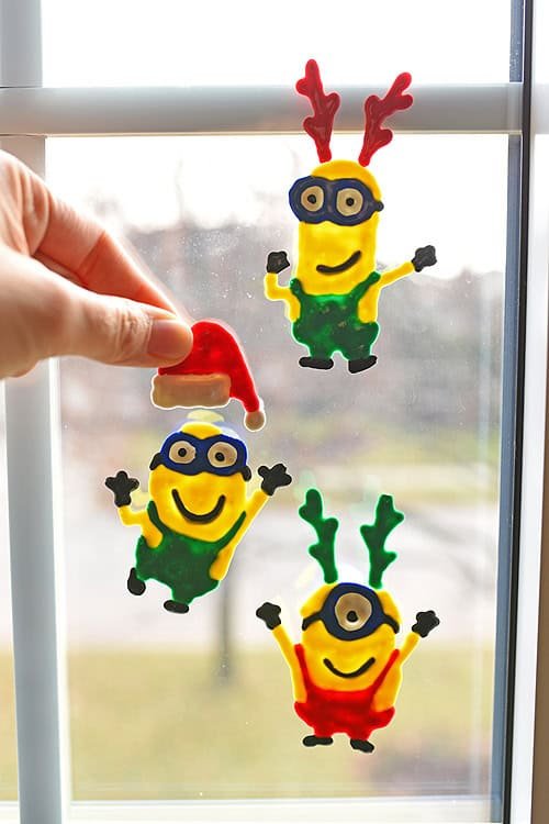 These holiday Minion window clings using Tulip slick paint are SO EASY and they look so cute! This is such a fun Christmas craft to do with the kids and it's seriously one of my all time favourite crafts!