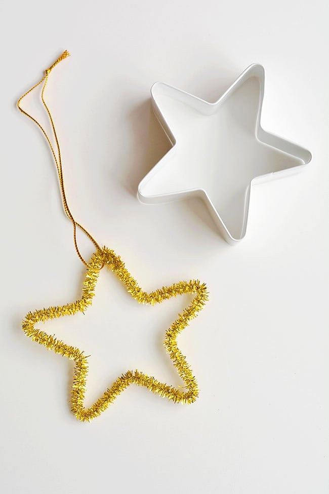 These easy star pipe cleaner ornaments are SO SIMPLE and they're so pretty! Using cookie cutters is such a brilliant way to make easy pipe cleaner shapes! This is such an easy Christmas craft and a super simple way for kids to make homemade Christmas ornaments. Such a great kids craft! Be sure to grab the instructions for how to make the rest of the fun pipe cleaner ornaments that go along with this twinkly star! Easy star pipe cleaner ornaments using a star cookie cutter as a guide