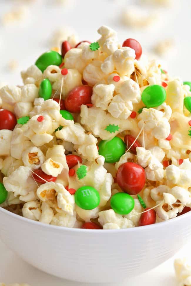 This marshmallow Christmas popcorn is SO GOOD and it's really simple to make. Such a great Christmas treat idea for kids and grown ups! I've also seen it called Santa Crunch Popcorn. Who knew marshmallow popcorn was a thing!? Top it with sprinkles and M&M's and this sweet and salty popcorn is delicious! (And perfect for the holidays!)