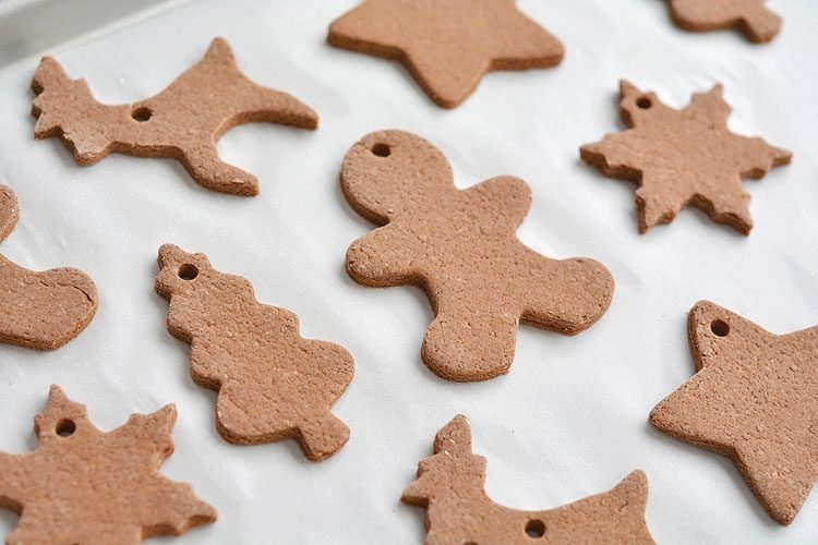 Various Christmas shaped cinnamon ornaments on a baking sheet