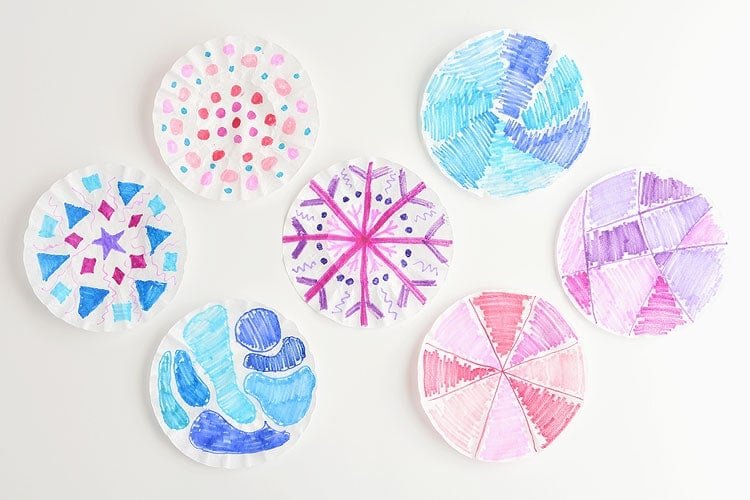 These coffee filter snowflakes are so easy to make and they are SO PRETTY! This is such a fun winter craft idea! A great activity for a snow day at home but also simple enough for teachers to make with the whole class at school. They make beautiful sun catchers and are a great Christmas decoration that can stay up all winter long! 