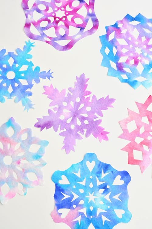 These coffee filter snowflakes are so easy to make and they are SO PRETTY! This is such a fun winter craft idea! A great activity for a snow day at home but also simple enough for teachers to make with the whole class at school. They make beautiful sun catchers and are a great Christmas decoration that can stay up all winter long! 