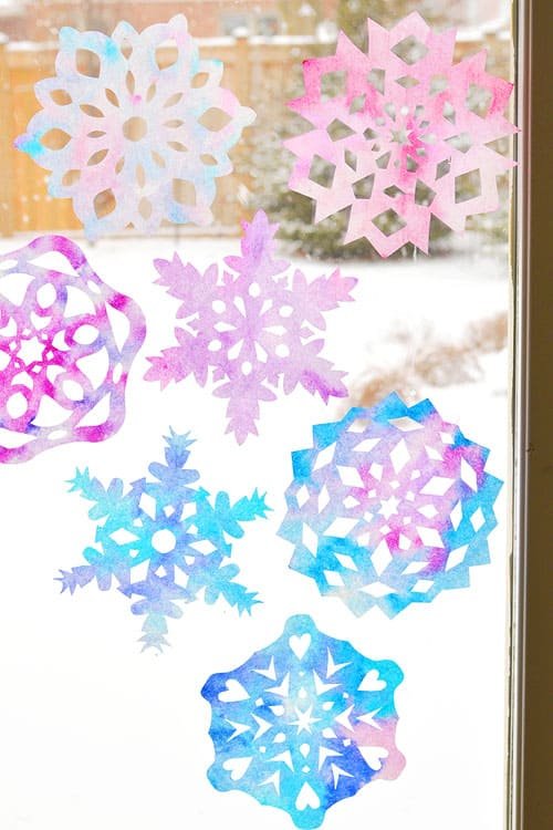 These coffee filter snowflakes are so easy to make and they are SO PRETTY! This is such a fun winter craft idea! A great activity for a snow day at home but also simple enough for teachers to make with the whole class at school. They make beautiful sun catchers and are a great Christmas decoration that can stay up all winter long! 