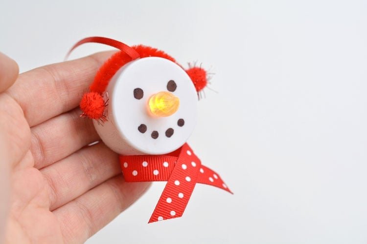 These tea light snowman ornaments are really easy to make and they look ADORABLE! Turn on the tea light and the "flame" becomes the snowman's carrot nose!