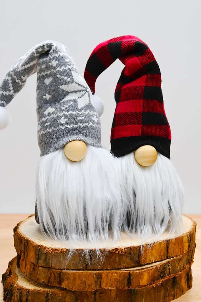 2 Christmas gnomes standing on wooden slabs