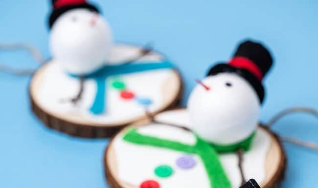 DIY Melting Snowman Ornament Melting snowman ornaments made on a wood slice