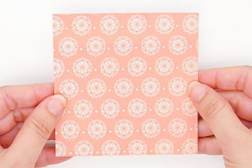 Square decorative paper held by two hands