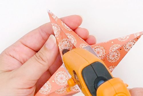 Hot glue being applied to a point of a paper star