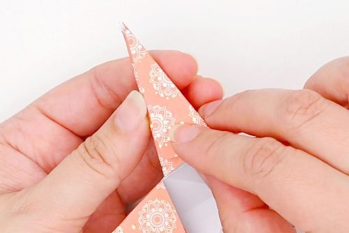 Hands folding paper flap over to create star point