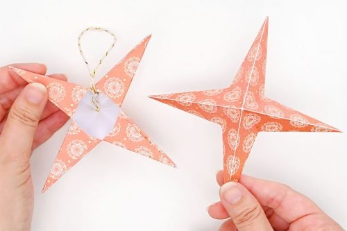 Paper star with string attached shown from behind and 2nd paper star shown from front to its right