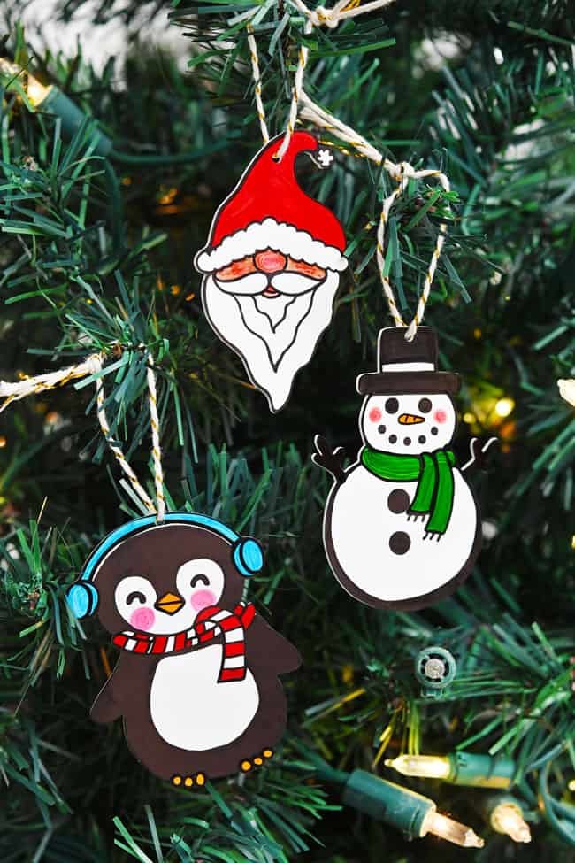 Santa, snowman, and penguin ornaments hanging on the Christmas tree