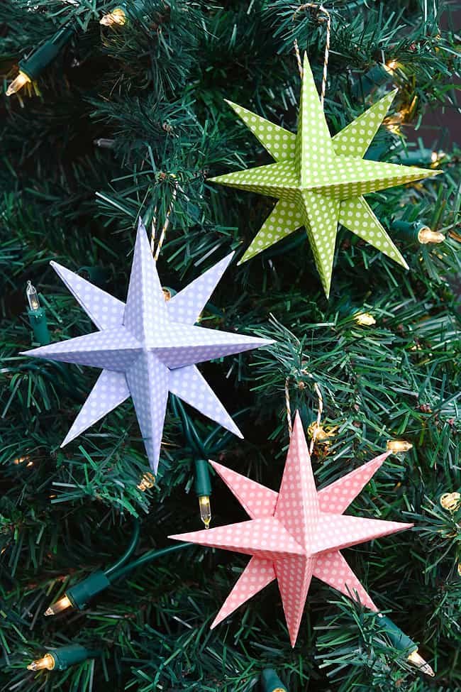 Group of colourful paper star ornaments hanging on a Christmas tree